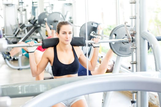 A young and beautiful woman working out at the gym