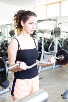 A young and beautiful woman working out at the gym