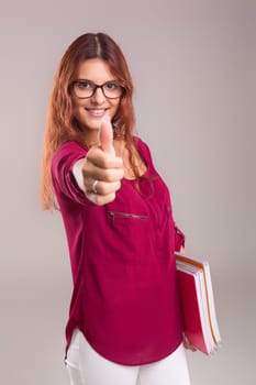 Studio shot of a young woman carrying some books