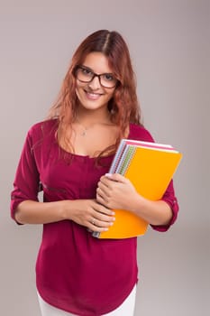 Studio shot of a young woman carrying some books