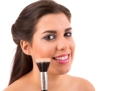 Portrait of a young and beautiful makeup artist with brushes