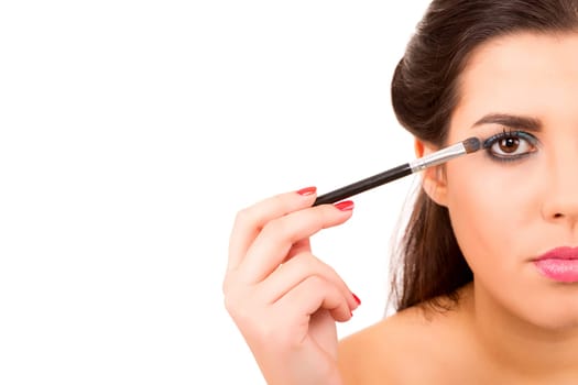 Portrait of a young and beautiful makeup artist with brushes
