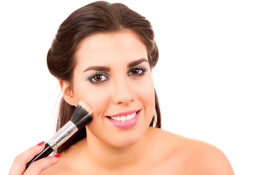 Portrait of a young and beautiful makeup artist with brushes