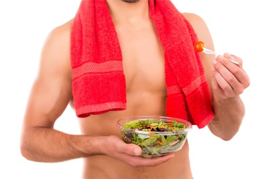Fit man holding a bowl of fresh salad after a training day