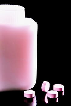 Close_up of pills with a pill bottle