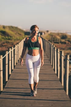 Young beautiful chinese woman exercising at the beach at sunrise/sunset