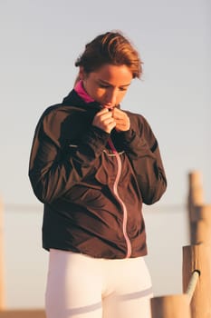Young beautiful chinese woman exercising at the beach at sunrise/sunset