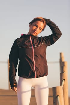 Young beautiful chinese woman exercising at the beach at sunrise/sunset