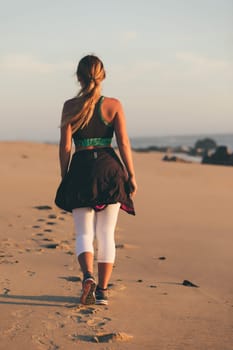 Young beautiful chinese woman exercising at the beach at sunrise/sunset