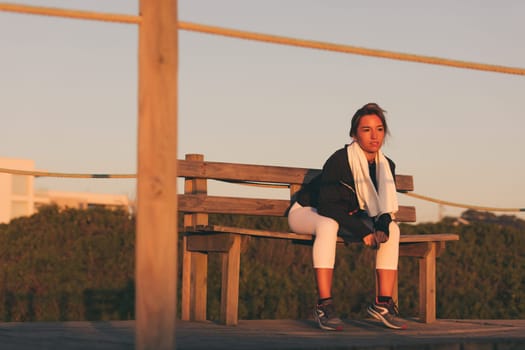 Young beautiful chinese woman exercising at the beach at sunrise/sunset