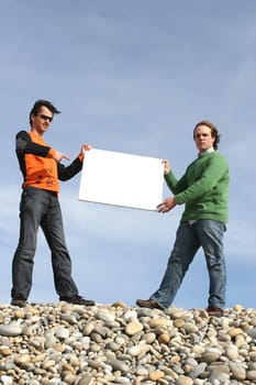 Two Young Men Holding White Card at the beach