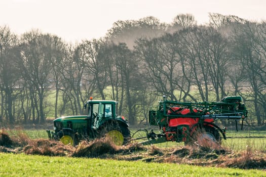 Tractor driving on a field with fertilizer in early spring