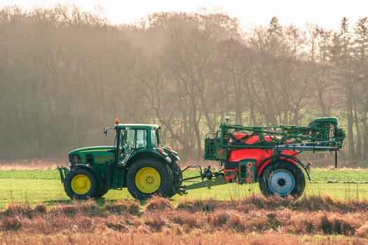 Tractor ferilizing a field in early spring