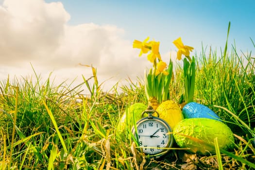 Easter eggs with daffodils and a clock