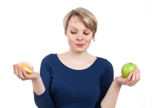 Young woman between donut and apple, isolated on white
