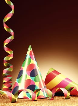 Close up Attractive Cone Hats and Paper Streamer for Party on Gradient Brown Background.