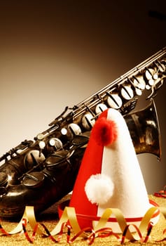 Close up Carnival Hat and Saxophone Instrument on Glittery Table, with Paper Streamers, In Front Gradient Brown Background. Emphasizing Copy Space.