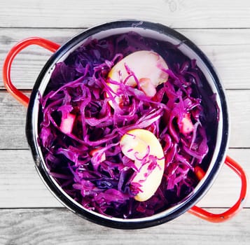 Close up Aerial Shot of Healthy Purple Cabbage and Apple Salad on Pot, Placed on Top of Wooden Table.