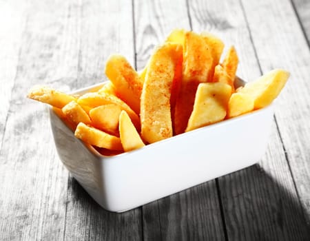 Close up Salted Fried steak French Fries on White Bowl, Placed on Gray Wooden Table.
