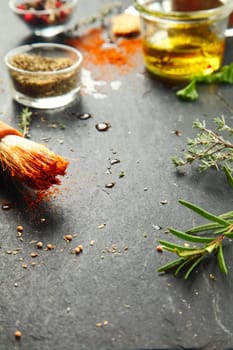 Close up Messy Black Kitchen Table with Fresh Herbs and Spices for Recipe.