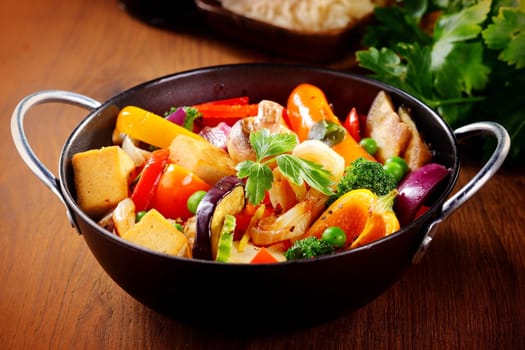 Close up Healthy Cooked Main Dish on Cooking Pan with Tofu, Mushrooms, Beans and Spices with Herbs. Placed on Wooden Table.