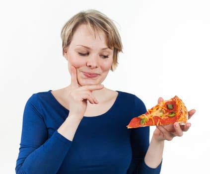 Young woman looking at a piece of pizza with appetite, isolated on white