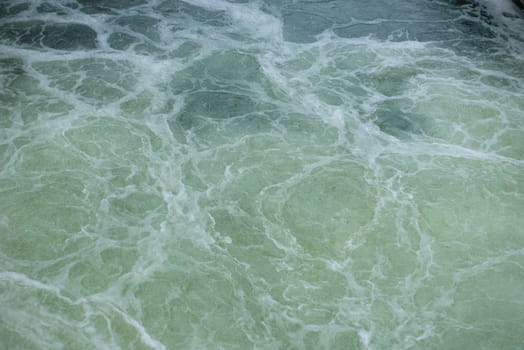 View on the textured surface of the seething river