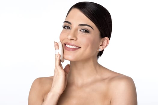 Topless woman applying cosmetic powder with puff