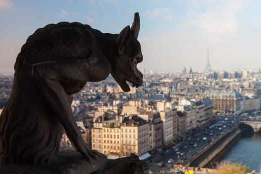Notre Dame of Paris: Famous Chimera (demon) overlooking the Eiffel Tower at a summer day