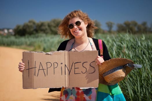 Pretty young woman holding happiness card