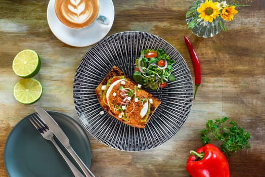 Smashed avocado with poached eggs, red pepper pesto and pickle shallot on toast top view