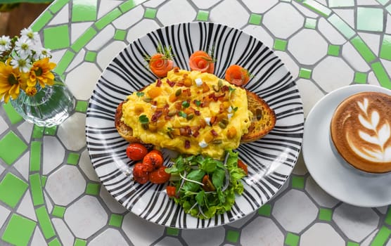 Toast with scrambled eggs pumpkin puree and cubes, smoked salmon and pumpkin seeds