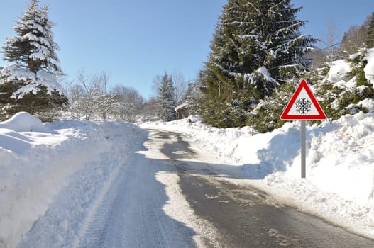 Warning sign at snow-covered road in Bavaria