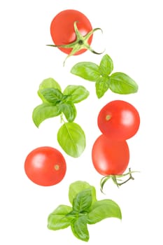 Isolated vegetables in the air. Seven whole tomatoesand basil leaves falling down on white with clipping path as package design element. Full depth of field. Food levitation concept