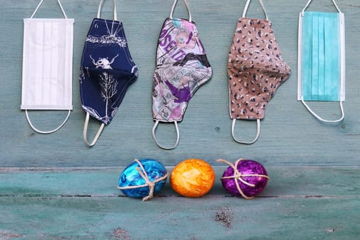 Corona and Easter. Protective masks and Easter eggs on a blue wooden background