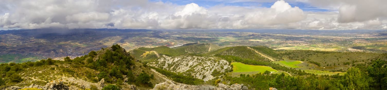 Springtime aerial landscape at La Silleta de Padul, Sierra Nevada, Andalucia, Spain. Dramatic cloudscape, with rain showers in the distance.