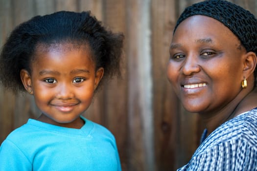 Portrait of cute African girl next to mother.
