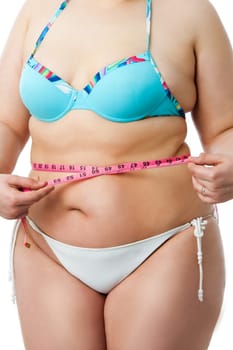Detail of obese female body with measuring tape.Isolated on white background.