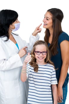 Little girl doing thumbs up sign together with older sister ready for dental check up.Isolated on white background.