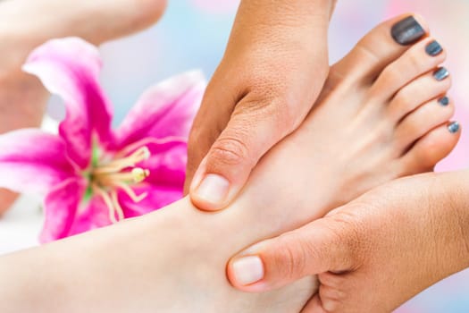 Extreme close up of Reflexologist working on female foot.