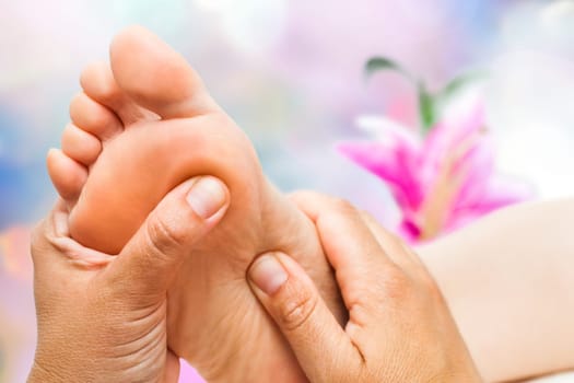 Macro close up of Reflexologist doing massage on female foot.