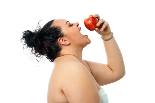 Close up studio shot of obese teen girl eating red apple.isolated on white background.