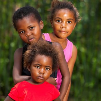 Close up facial portrait of three african girls together outdoors.