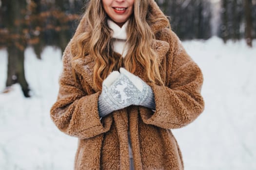 Young woman in fur coat, gloves and scarf in snowy forest. High quality photo