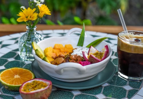 Granola with greek yogurt, honey, fresh fruits, chia seeds served with ice americano