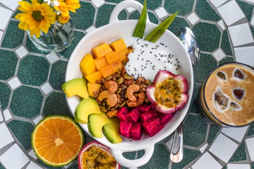 Granola with greek yogurt, honey, fresh fruits, chia seeds served with ice americano