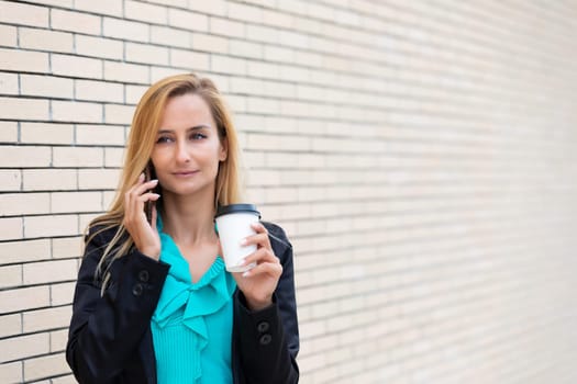 Successful businesswoman or entrepreneur talking on cellphone while outdoor. City business woman working.
