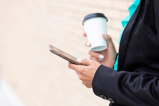 Business woman with coffe and talking on the phone near office