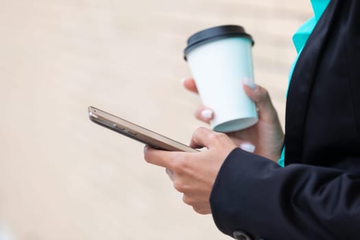 Business woman with coffe and talking on the phone near office