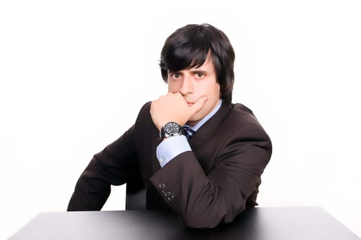 Young Businessman over a desk, full of thoughts, isolated in white